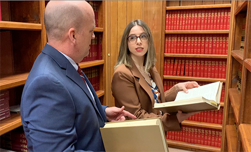 Attorneys looking through books in a library